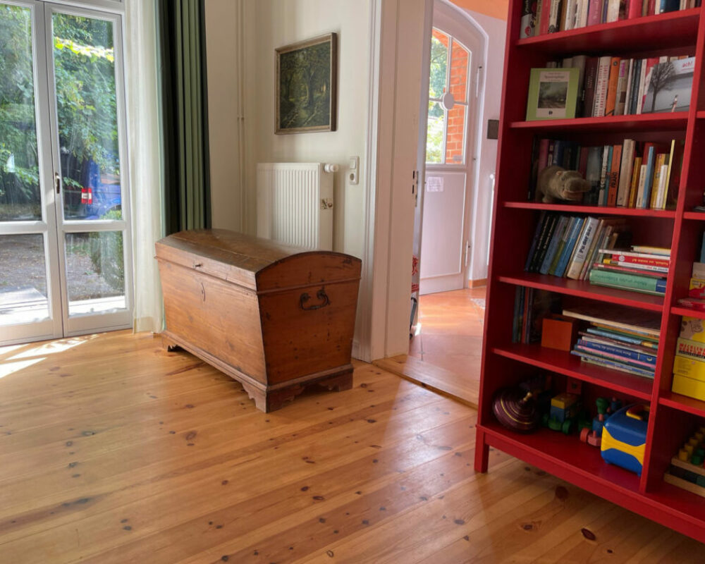 Kleine Ferienwohnung – Wohnzimmer mit Spieleregal